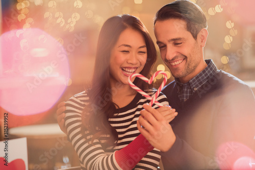 Couple holding heart-shape candy canes photo