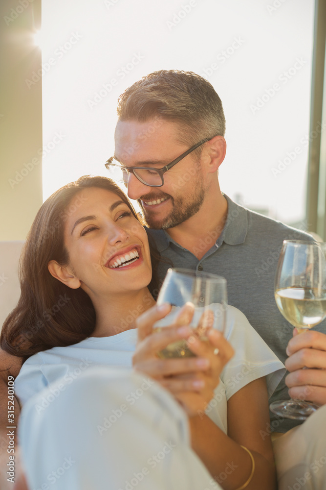 Affectionate couple smiling and drinking white wine Affectionate couple smiling and drinking white wine