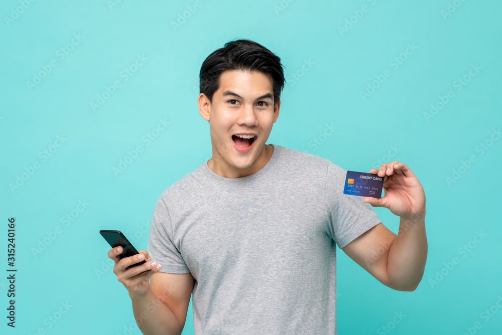 Handsome young Asian man showing credit card in hand Handsome young Asian man showing credit card in hand