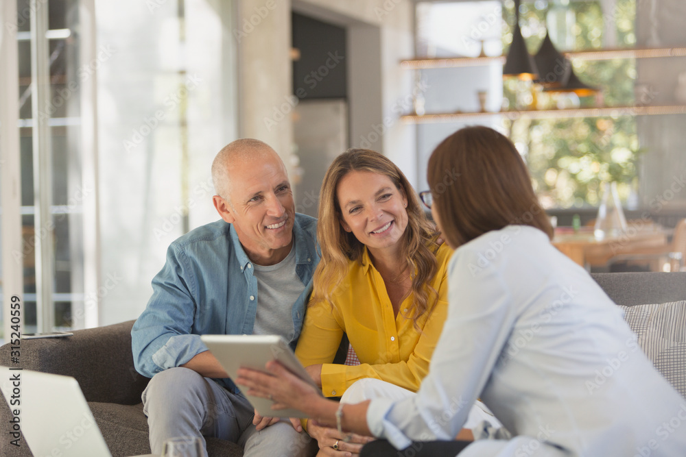 © Tom Merton/Caia Image - Financial advisor with digital tablet meeting with couple in living room © Tom Merton/Caia Image - Financial advisor with digital tablet meeting with couple in living room