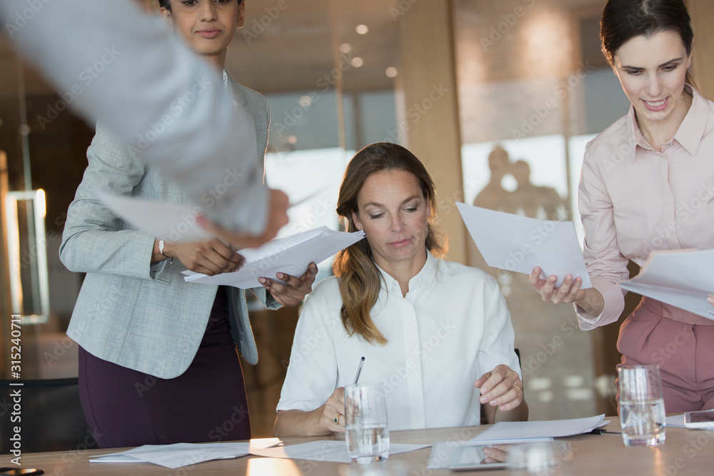 Business people signing and reviewing paperwork in conference room meeting Business people signing and reviewing paperwork in conference room meeting