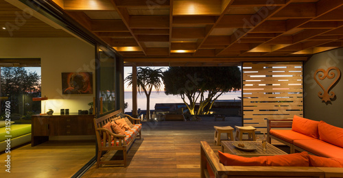 Illuminated modern, luxury home showcase interior living room open to patio