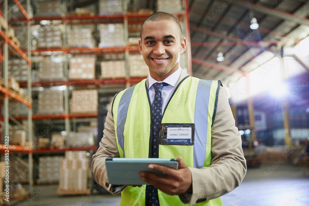 © Ryan Lees/Caia Image - Portrait confident manager with digital tablet in distribution warehouse