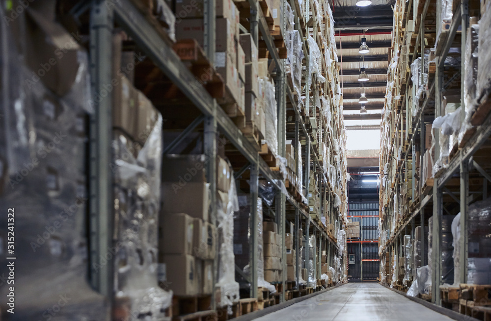 Merchandise cardboard boxes stacked on shelves in distribution warehouse Merchandise cardboard boxes stacked on shelves in distribution warehouse