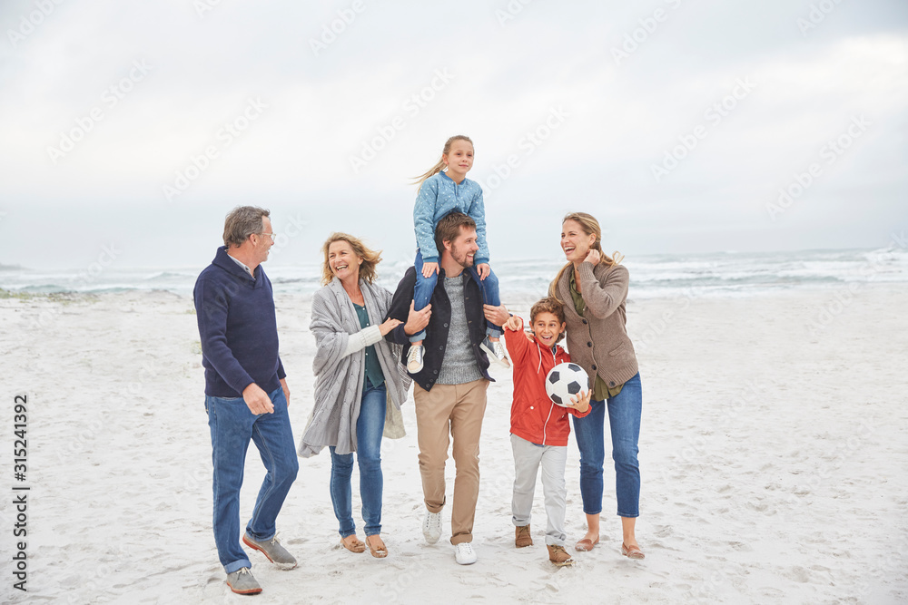 Multi-generation family walking on winter beach Multi-generation family walking on winter beach