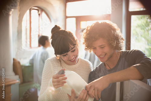 Young couple roommates looking at expiration date on milk in kitchen