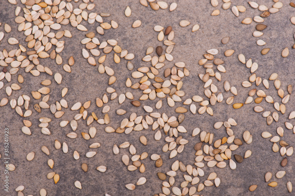 Sesame seeds on a brown textured background, healthy food