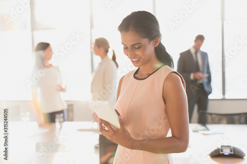 Wallpaper Mural Businesswoman using digital tablet in sunny conference room Torontodigital.ca