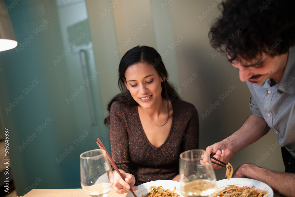 Couple eating dinner with chopsticks Couple eating dinner with chopsticks