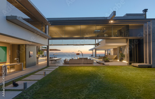 Illuminated modern, luxury home showcase courtyard and house photo