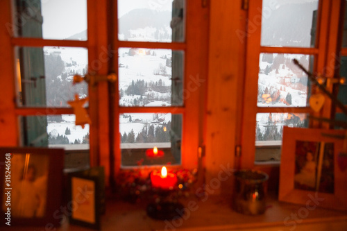 Christmas candle in window overlooking tranquil snowy landscape, Forclaz, Switzerland photo