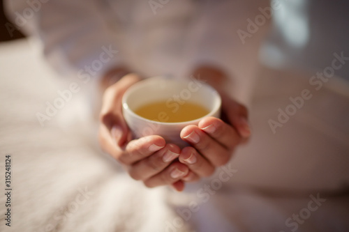 Close up woman cupping hot tea
