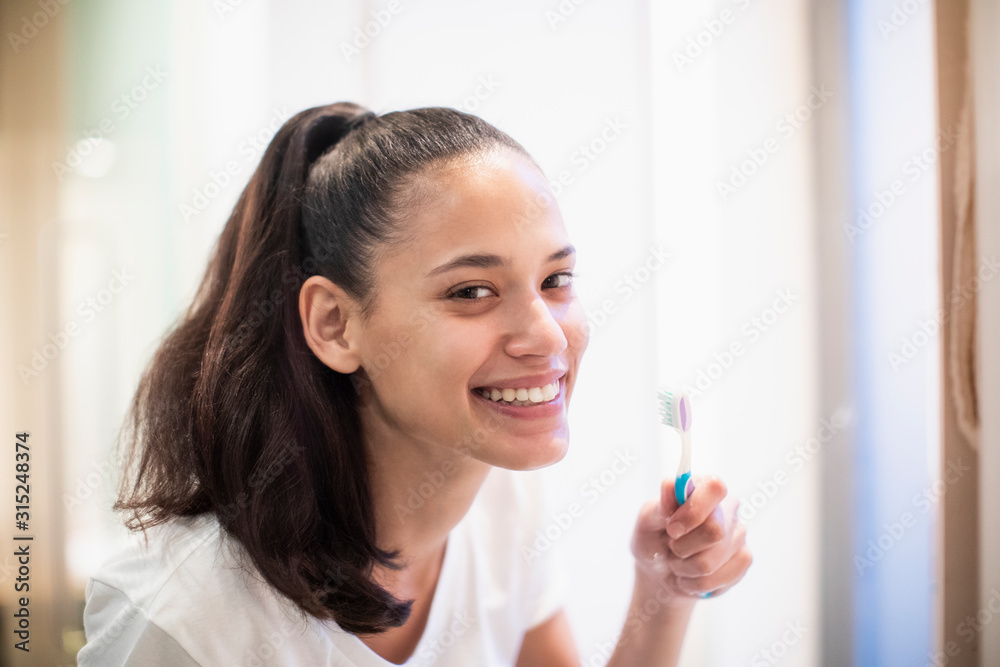 Portrait smiling, confident woman brushing teeth in bathroom mirror Portrait smiling, confident woman brushing teeth in bathroom mirror