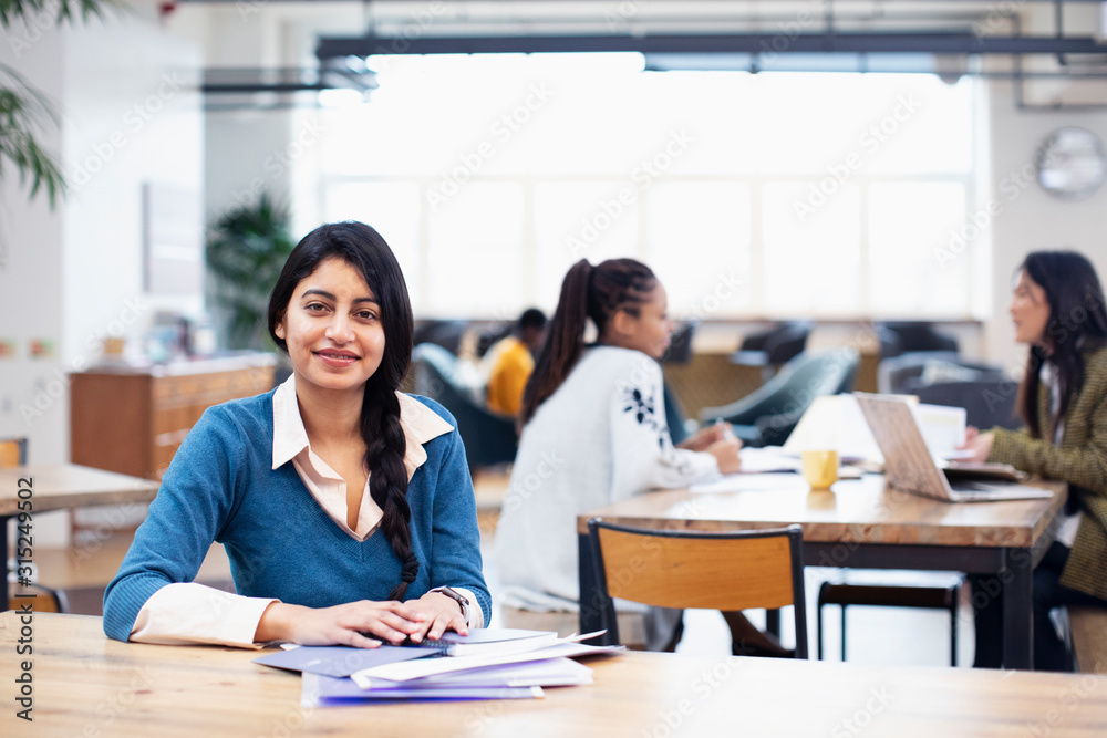 Portrait confident businesswoman working in open plan office Portrait confident businesswoman working in open plan office