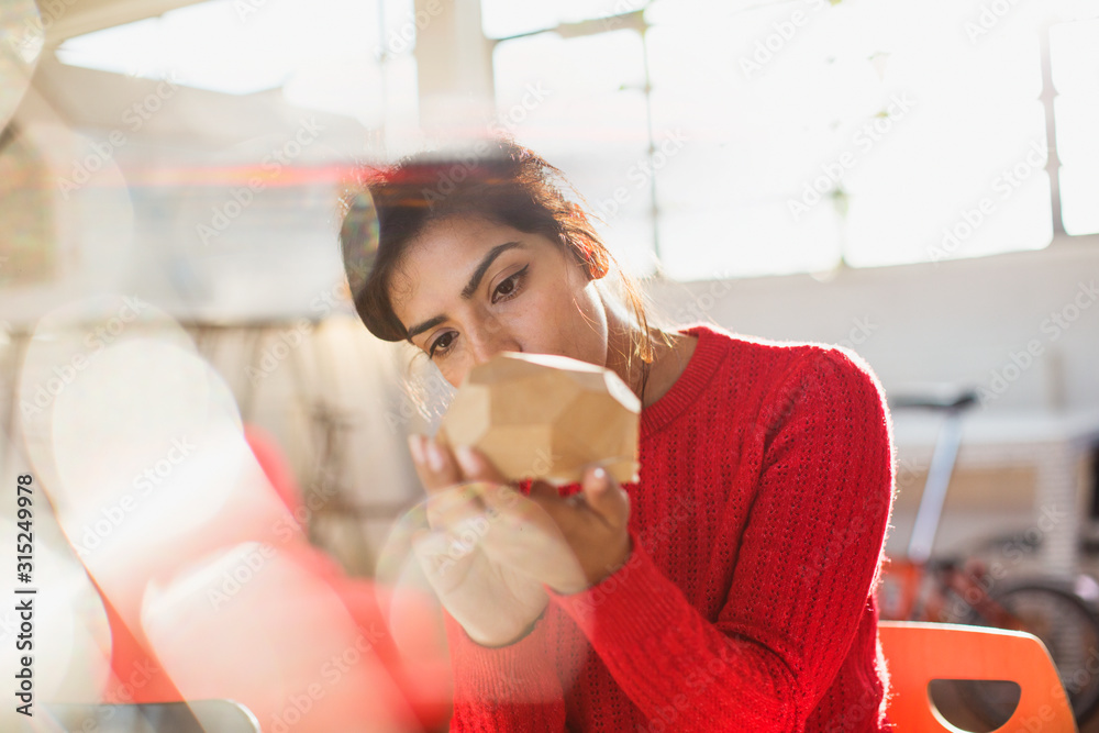 © Tom Merton/Caia Image - Focused female engineer examining prototype in sunny office
