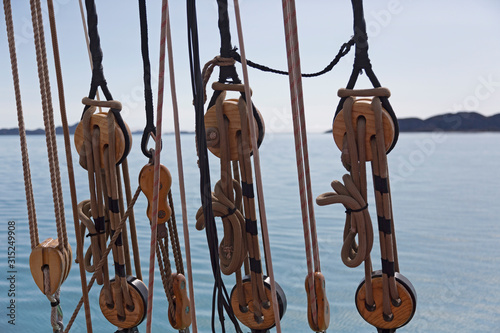 Wooden sailboat pulleys and rigging on ocean