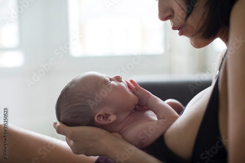 Mother holding newborn baby son photo