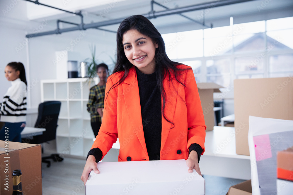 © Sam Edwards/Caia Image - Portrait confident businesswoman moving into new office © Sam Edwards/Caia Image - Portrait confident businesswoman moving into new office