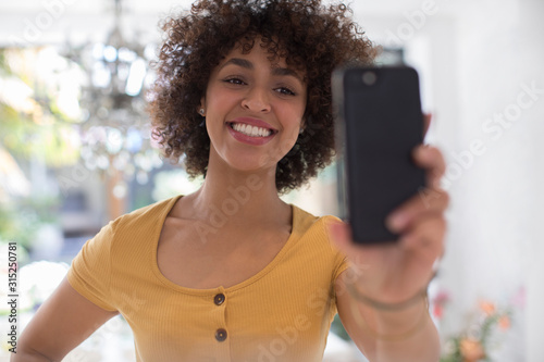 Happy young woman taking selfie with camera phone
