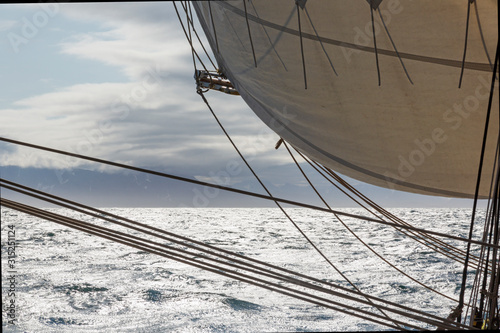 Sailboat sail and rigging over sunny Atlantic Ocean photo