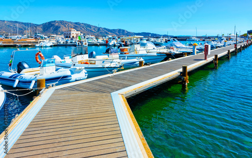 Old Sardinian Port and marina with ships at Mediterranean Sea in city of Villasimius in South Sardinia Island Italy in summer. Cityscape with Yachts and boats