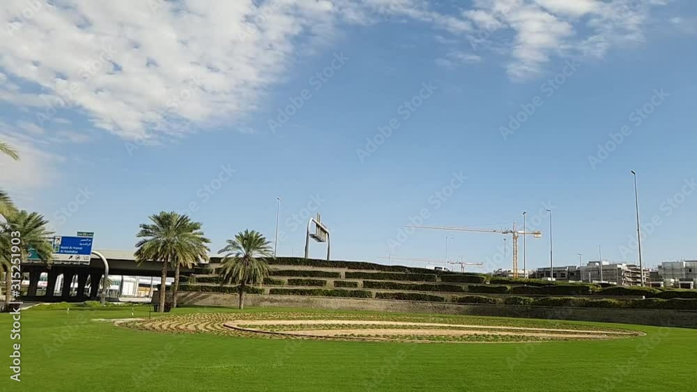Garden with palm trees on road verge in Dubai, UAE, tracking left Garden with palm trees on road verge in Dubai, UAE, tracking left