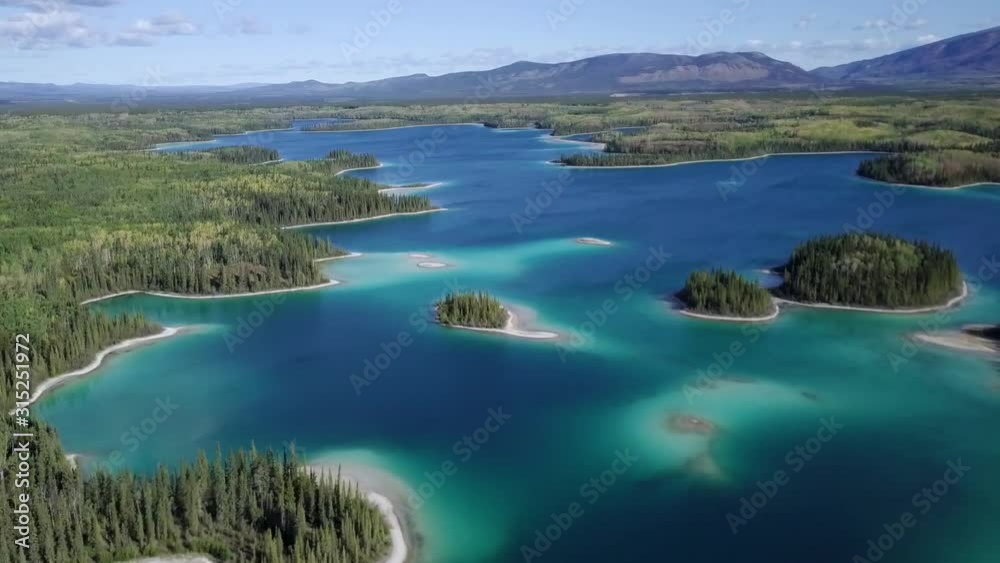 Aerial flying over Boya lake and it’s aquamarine waters in the British Columbia, Canada Aerial flying over Boya lake and it’s aquamarine waters in the British Columbia, Canada
