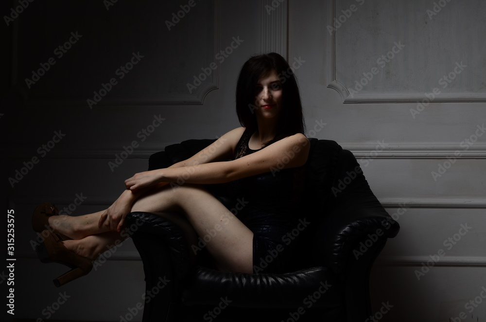 Sexy young brunette woman, wearing a mini black dress, in glamour full length, on gray background Sexy young brunette woman, wearing a mini black dress, in glamour full length, on gray background