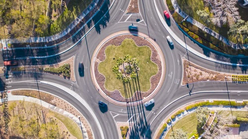 Aerial timelapse of cars driving in busy, pretty traffic circle roundabout  photo