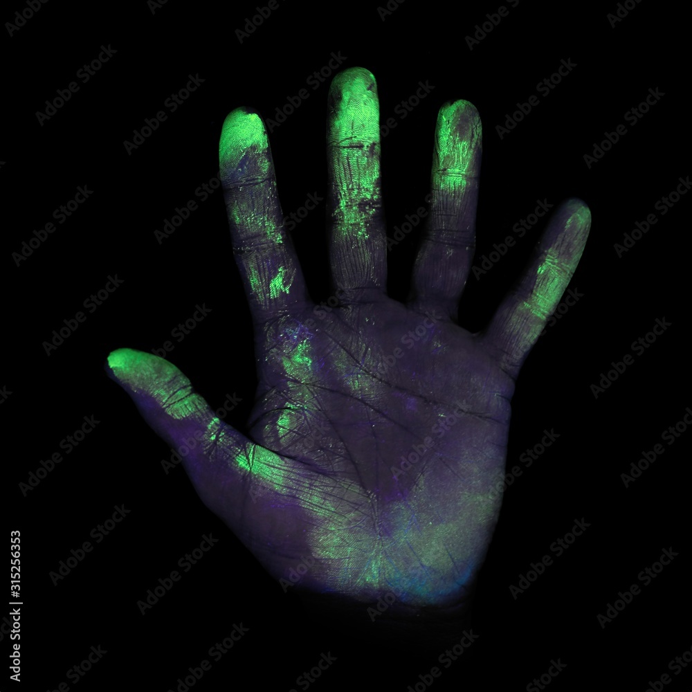 UV light showing bacteria on hand UV light showing bacteria on hand