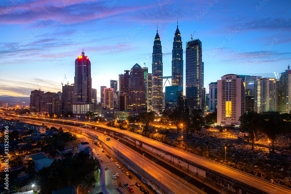 Fototapeta premium Wieżowiec miasta Kuala Lumpur i ulica autostrady z ładnym wschodem słońca na niebie w dzielnicy biznesowej w centrum Kuala Lumpur. Malezja. Malezja turystyka, nowoczesne życie w mieście lub finanse i ekonomia biznesu