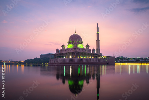 Putrajaya mosque or pink mosque with lake between sunrise in Kuala Lumpur, Malaysia. Malaysia tourism, history building, or tradition culture and travel concept