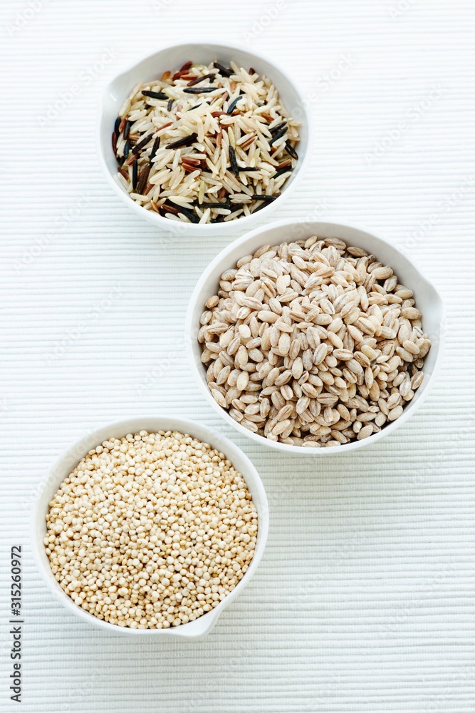 Barley, rice and quinoa in bowls Barley, rice and quinoa in bowls