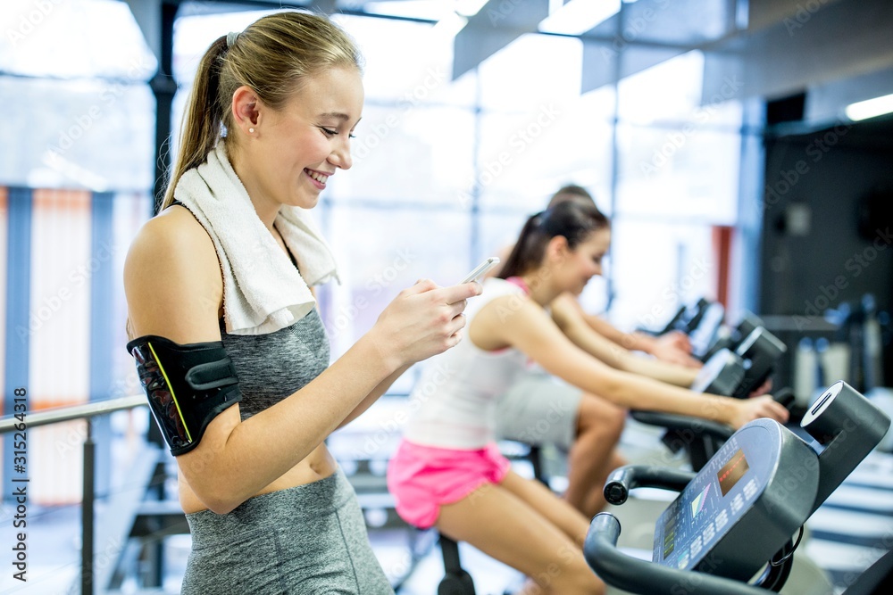 Woman using phone in gym