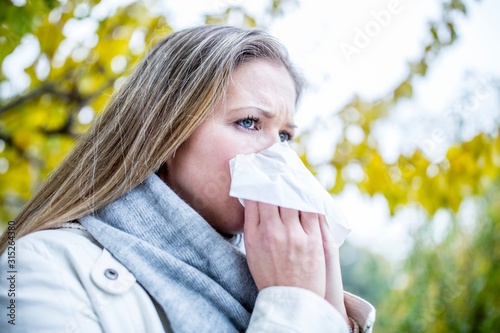 Young woman sneezing photo