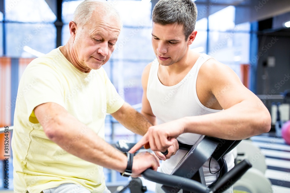 Senior man exercising with trainer Senior man exercising with trainer