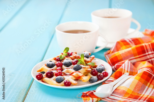 Homemade wafers with berries and tea on a table. Selective focus. Copy space.