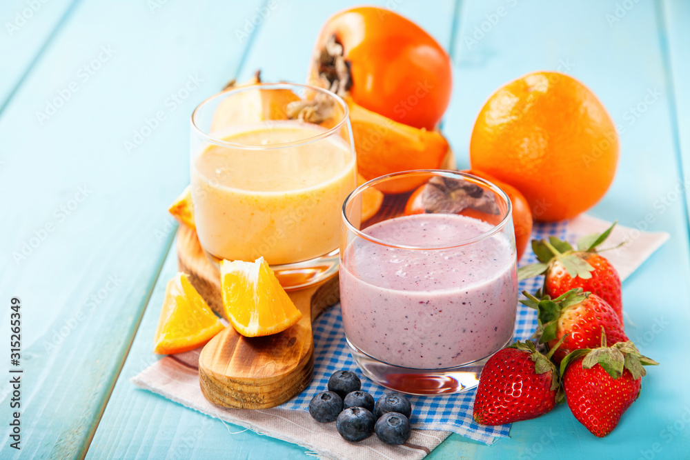 Orange persimmon blueberry smoothie with granola  and fruits. Selective focus. Copy space