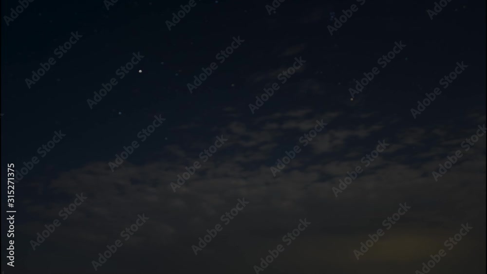 Time lapse of scattered clouds drifting away in front of stars at dusk. Time lapse of scattered clouds drifting away in front of stars at dusk.