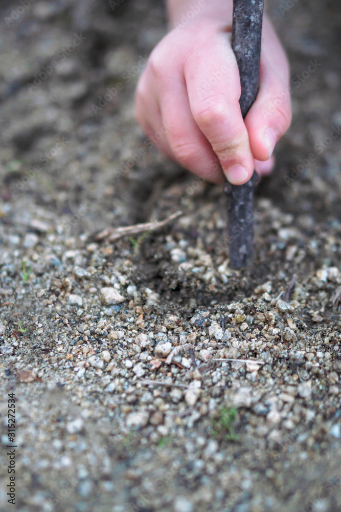 Child drawing a circle on the soil. Montessori work. Child drawing a circle on the soil. Montessori work.