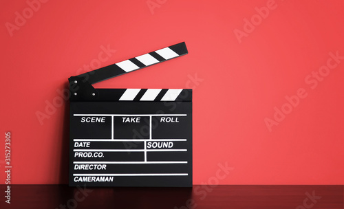 Blank Film clapper board or movie clapper cinema board , Slate film on black wooden with red wall background .cinema concept © kasarp
