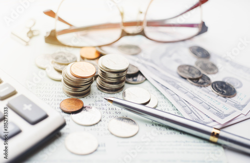 Coins and saving account book on office desk table , saving money concept ,selective focus