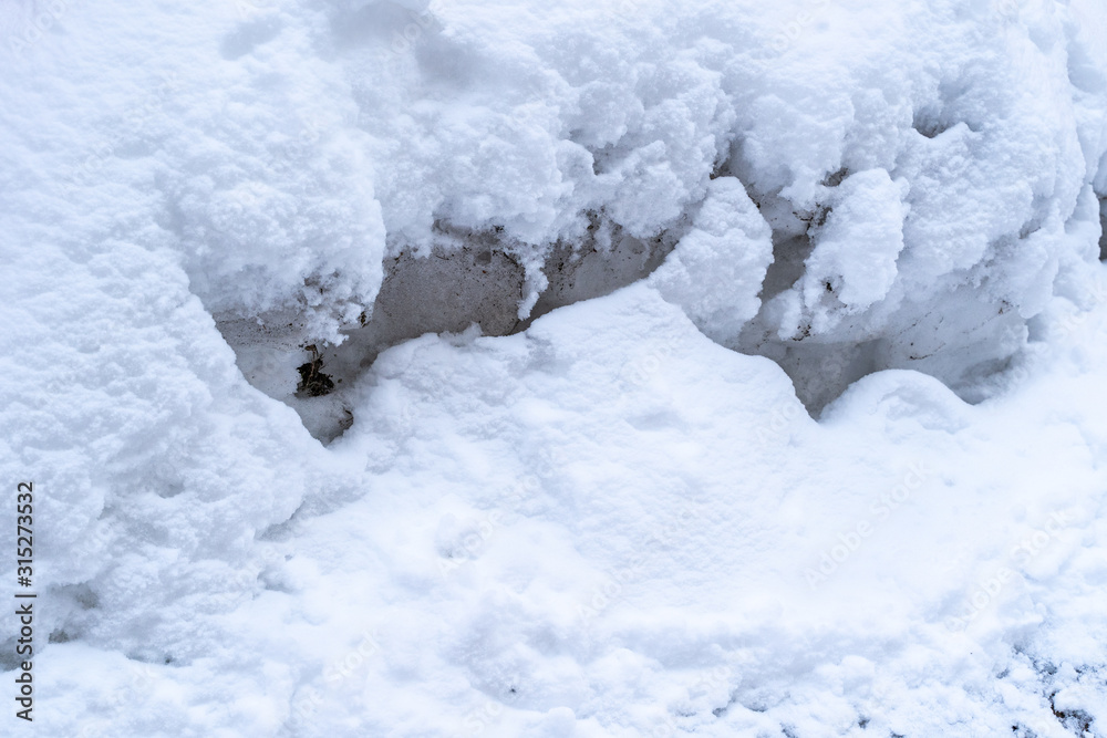 Thick pile of snow covers concrete wall Thick pile of snow covers concrete wall