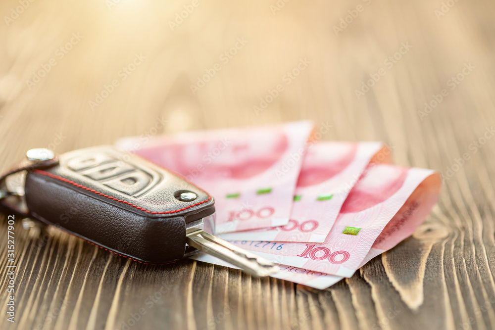New car keys with Chinese banknote on wooden table. Car purchase or car  rental concept. Stock Photo | Adobe Stock