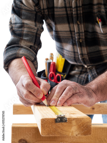 Close-up. Carpenter with pencil and the meter marks the measurement on a wooden board. Construction industry. White background.