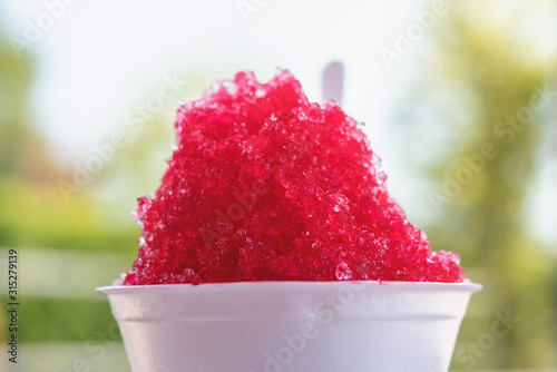 Shaved ice with sweet sala red syrup in foam cup.