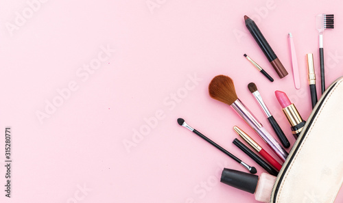 Make-up cosmetic bag against pink background, copy space photo