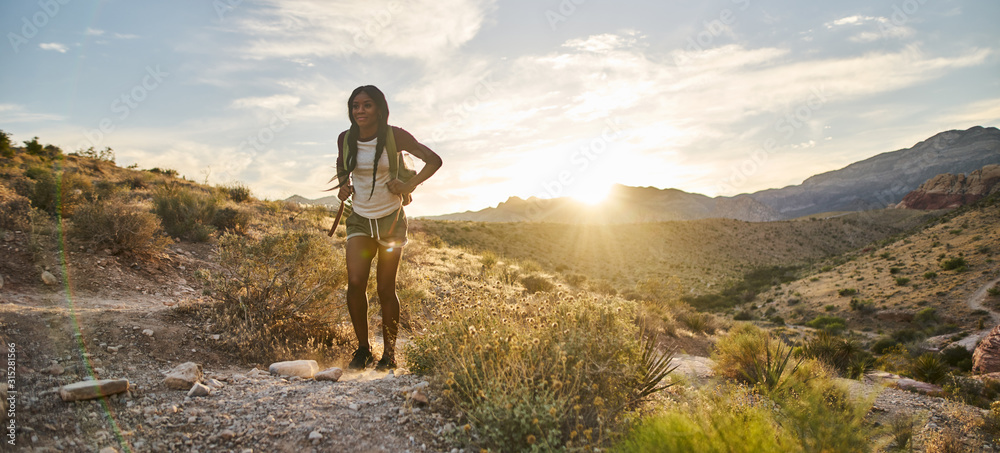 woman hiking at Red Rock Canyon during sunset with backpack - obrazy, fototapety, plakaty 