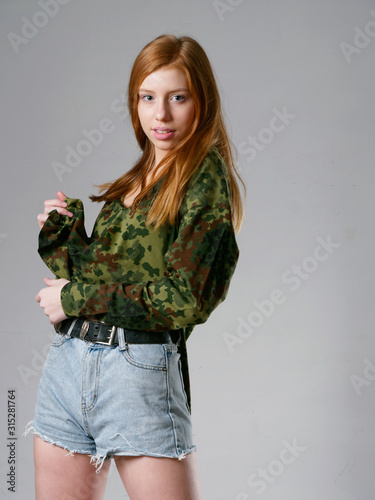 young girl with long red hair on a gray background
