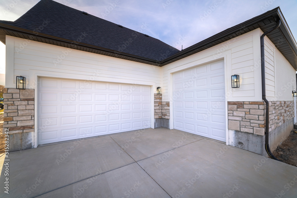 Fototapeta premium Two garage doors sharing a paved forecourt